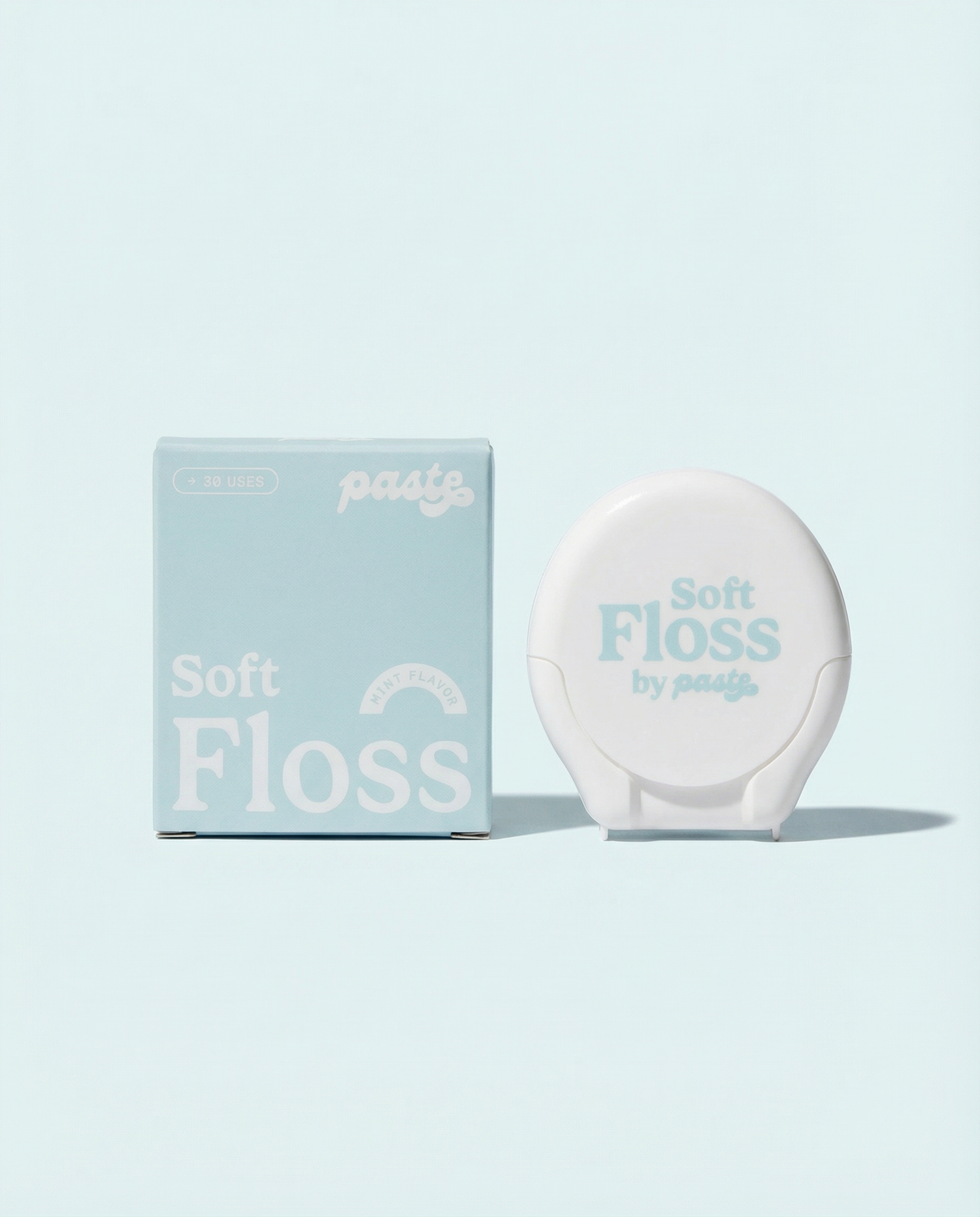 Light blue box and white compact for Paste Soft Floss in Mint flavor (30 uses) displayed side by side on a pale blue background.