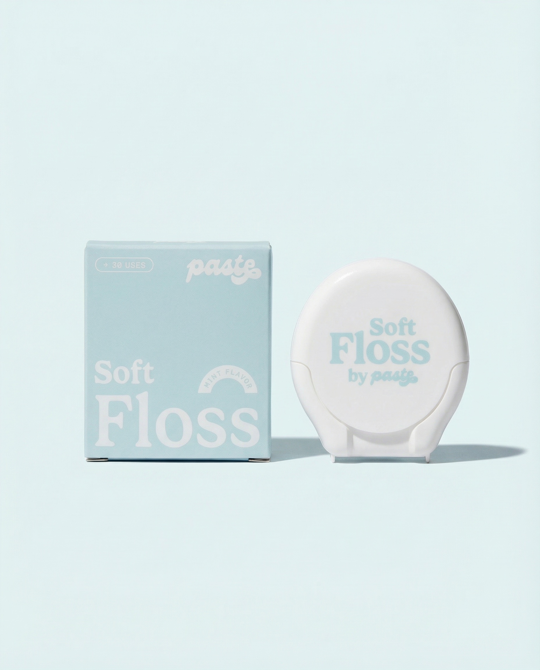 Light blue box and white compact for Paste Soft Floss in Mint flavor (30 uses) displayed side by side on a pale blue background.